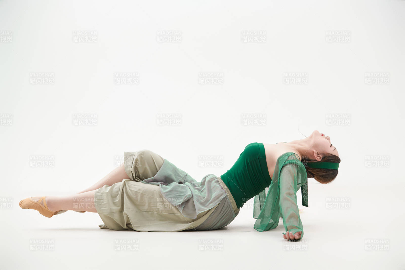 身穿青色古典舞蹈服裝手拿蒲扇跳舞的少女