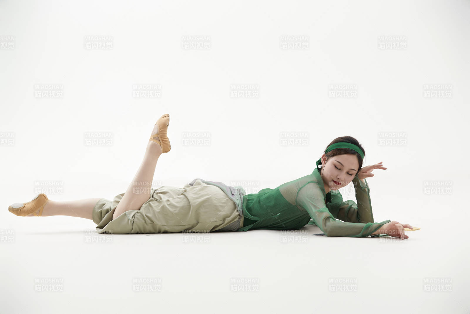 身穿青色古典舞蹈服裝手拿蒲扇跳舞的少女