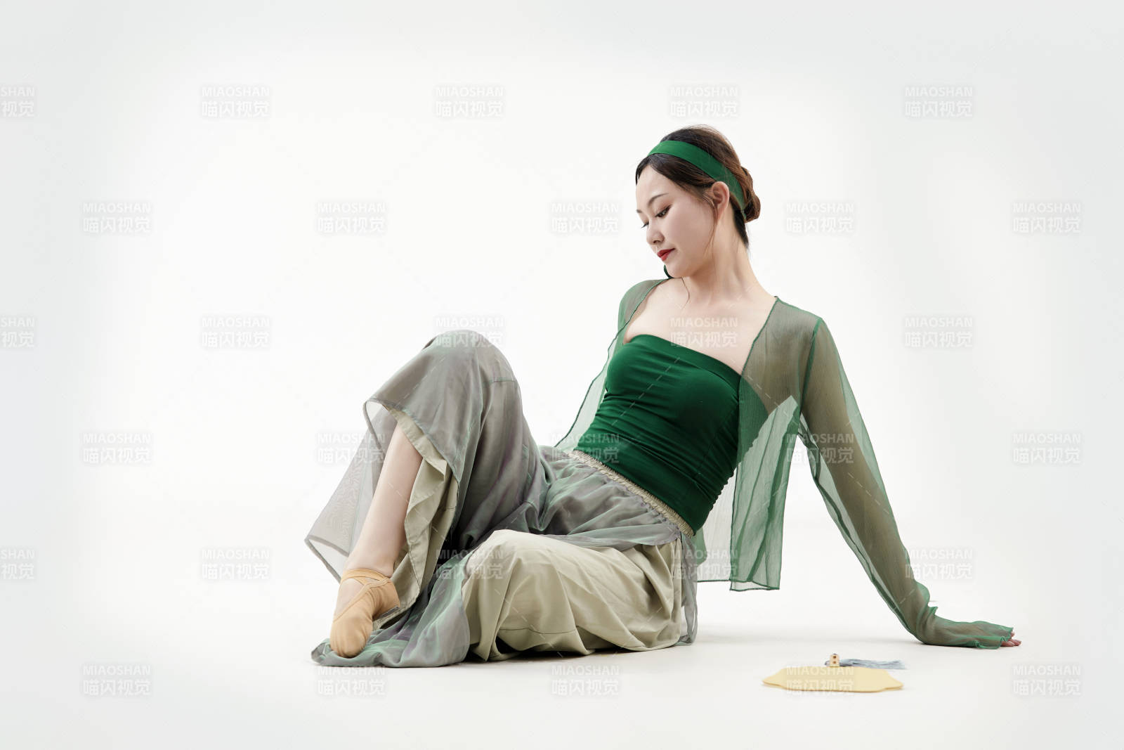 身穿青色古典舞蹈服裝手拿蒲扇跳舞的少女