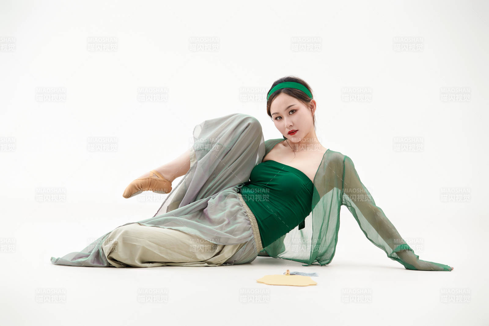 身穿青色古典舞蹈服裝手拿蒲扇跳舞的少女