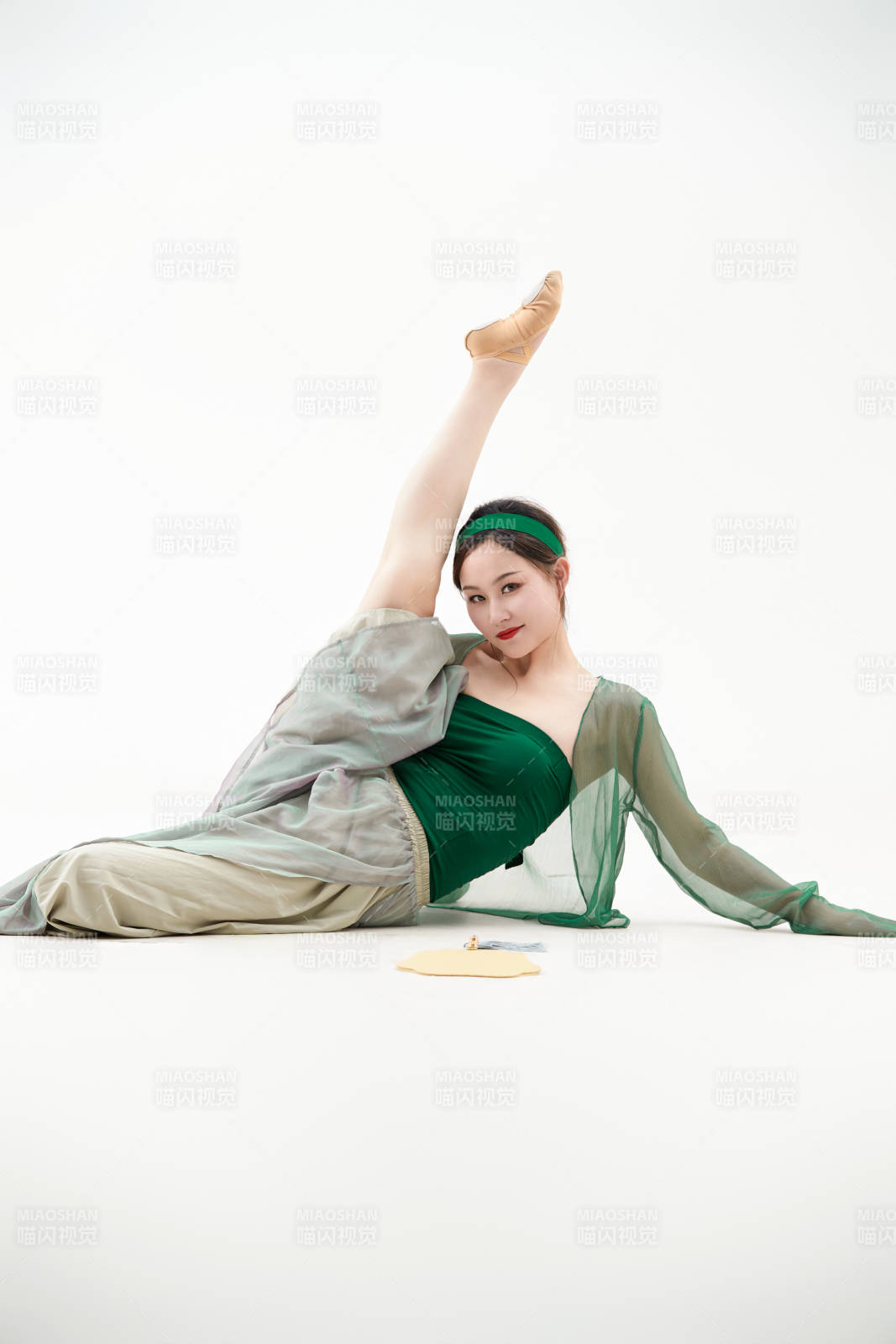 身穿青色古典舞蹈服裝手拿蒲扇跳舞的少女