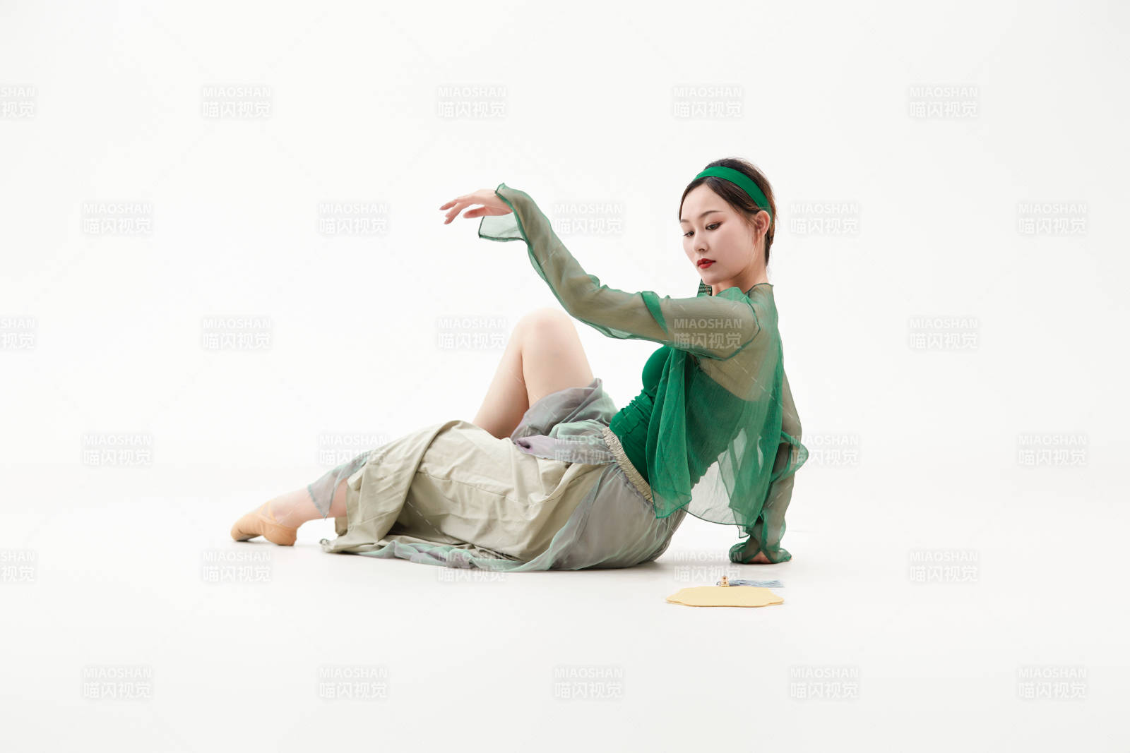 身穿青色古典舞蹈服裝手拿蒲扇跳舞的少女