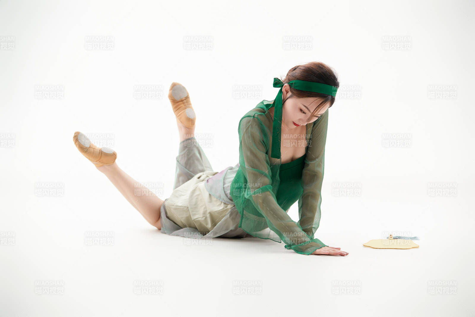 身穿青色古典舞蹈服裝手拿蒲扇跳舞的少女