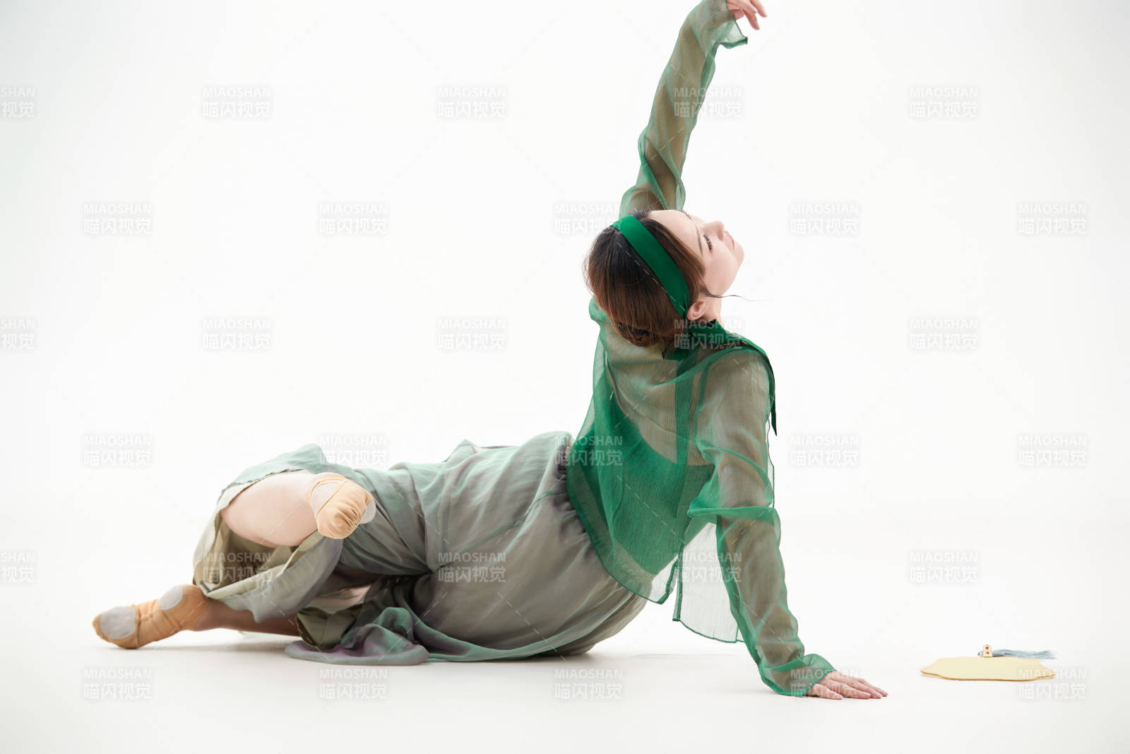 身穿青色古典舞蹈服裝手拿蒲扇跳舞的少女