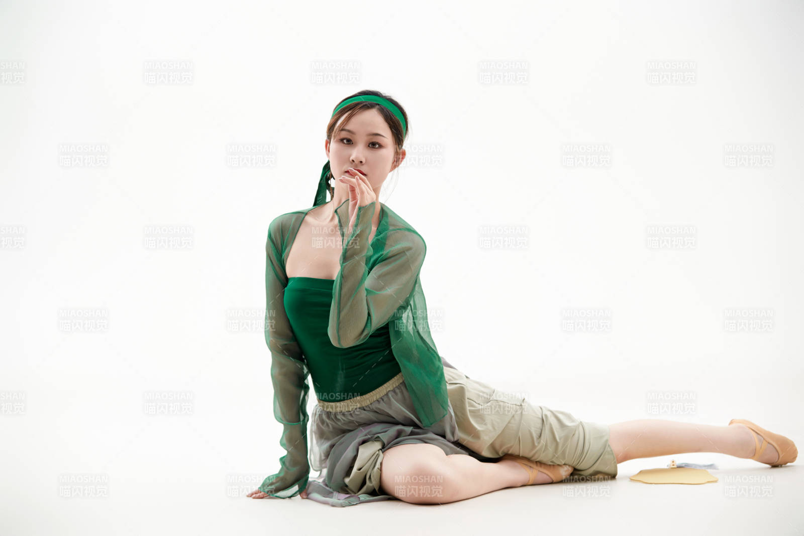 身穿青色古典舞蹈服裝手拿蒲扇跳舞的少女