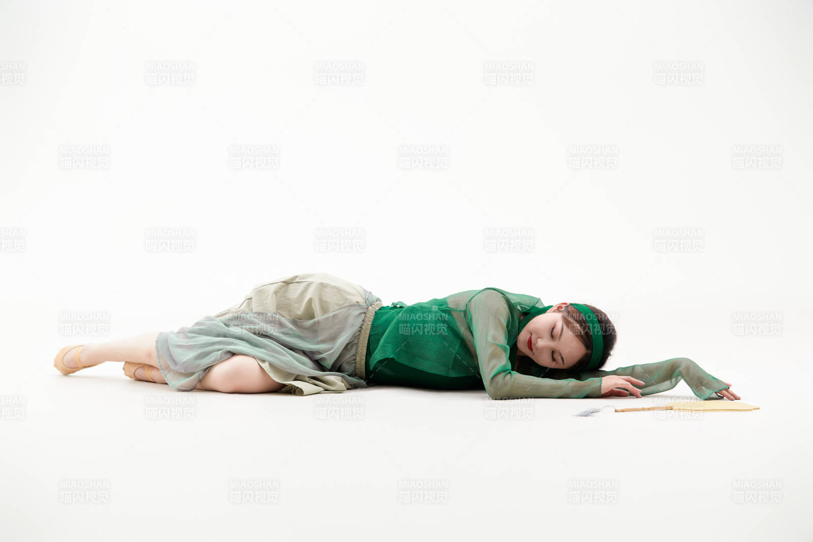 身穿青色古典舞蹈服裝手拿蒲扇跳舞的少女