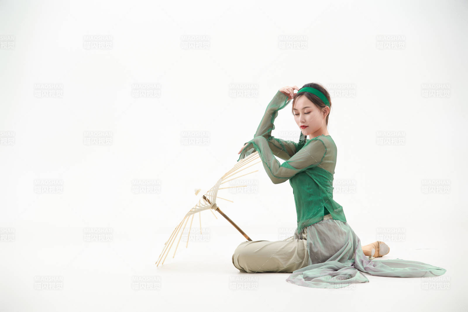 身穿青色古典舞蹈服裝手拿蒲扇跳舞的少女