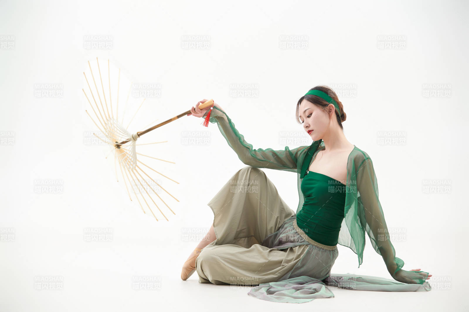 身穿青色古典舞蹈服裝手拿蒲扇跳舞的少女