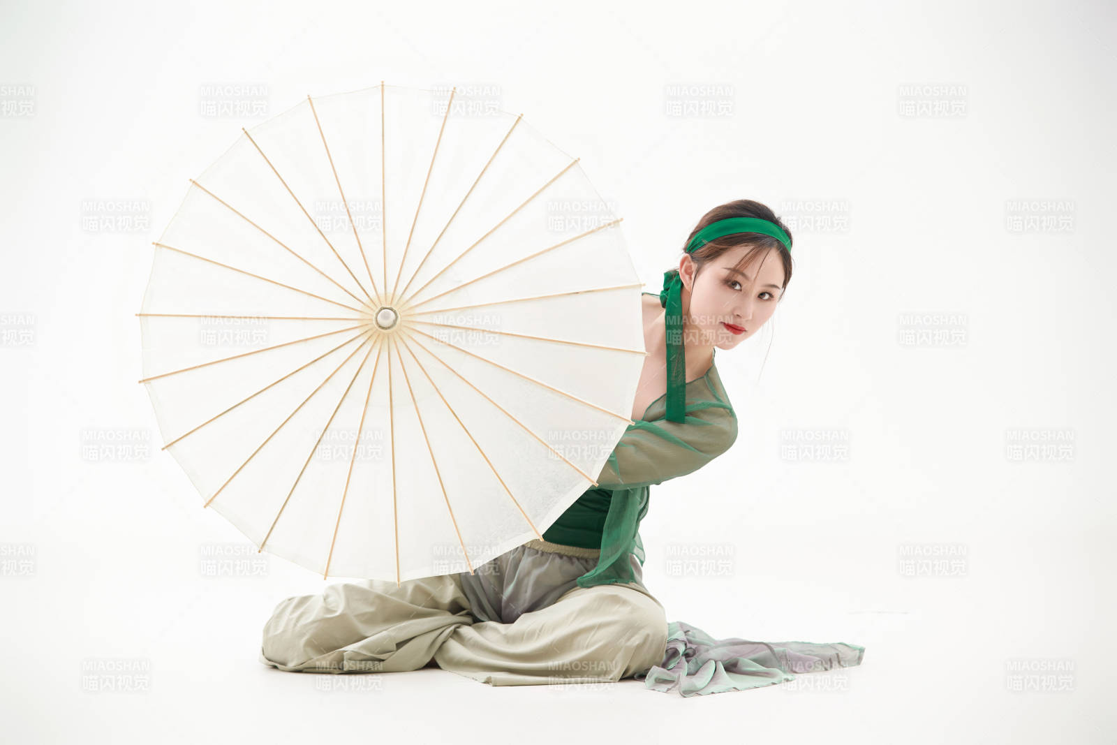 身穿青色古典舞蹈服裝手拿蒲扇跳舞的少女