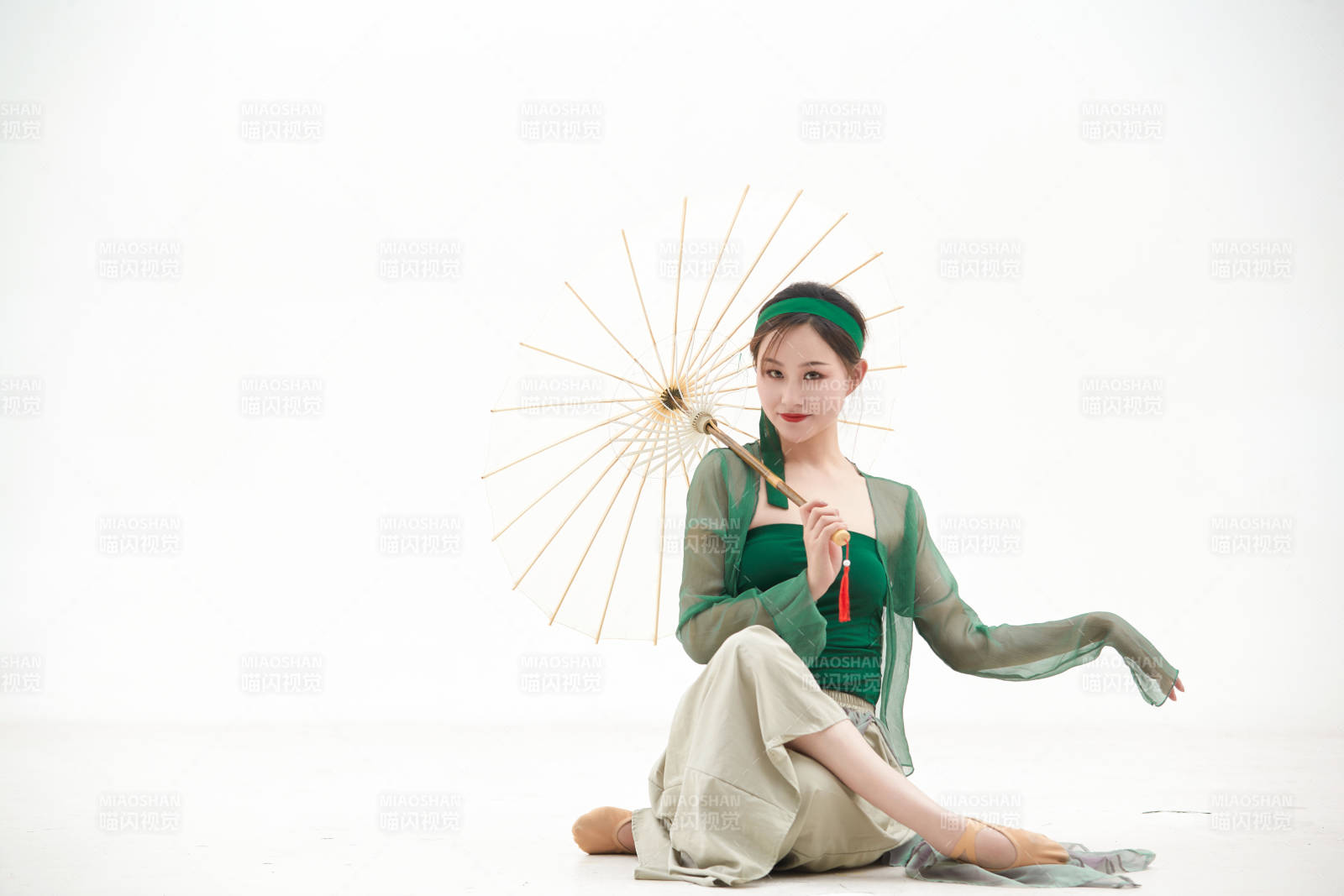 身穿青色古典舞蹈服裝手拿蒲扇跳舞的少女