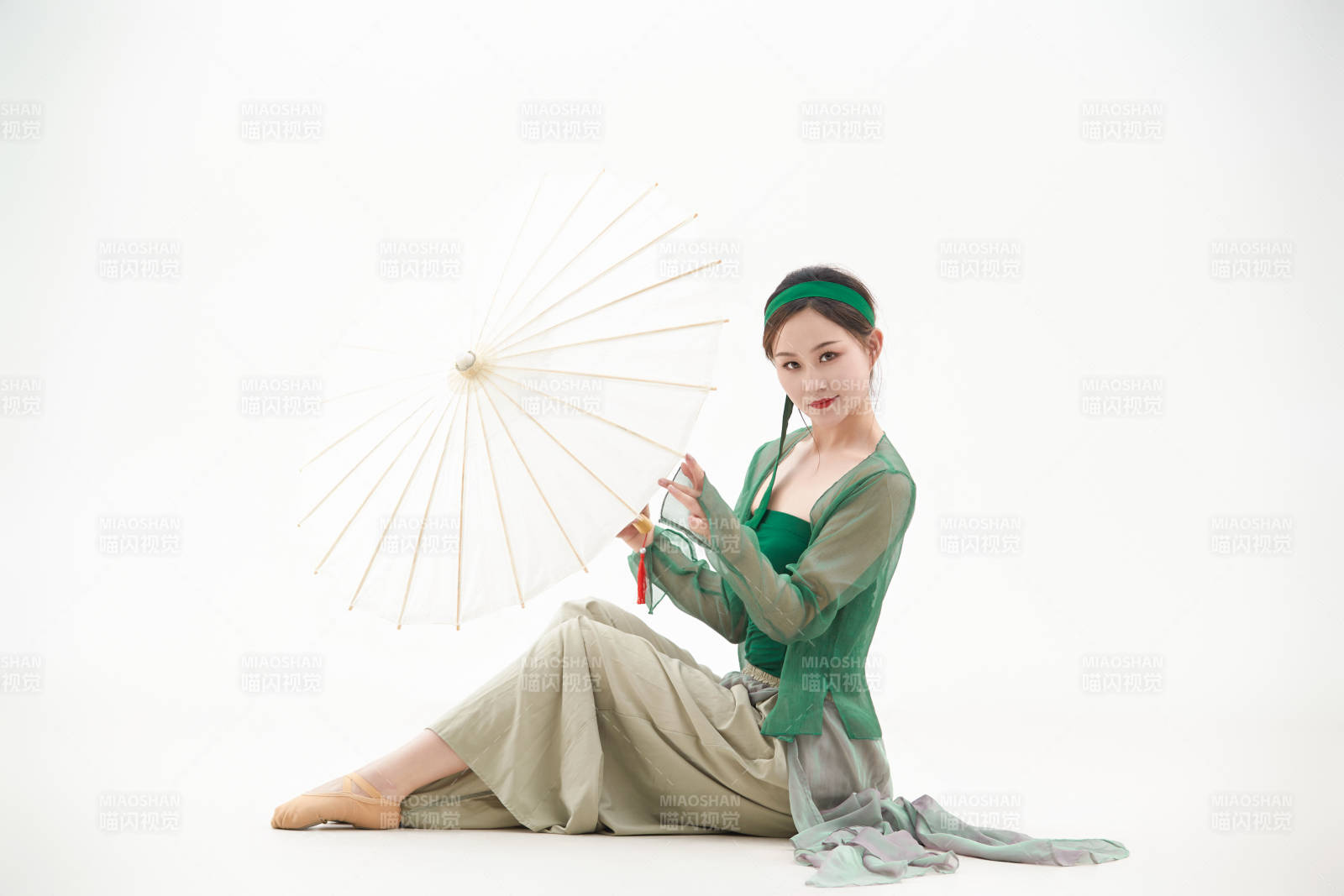 身穿青色古典舞蹈服裝手拿蒲扇跳舞的少女