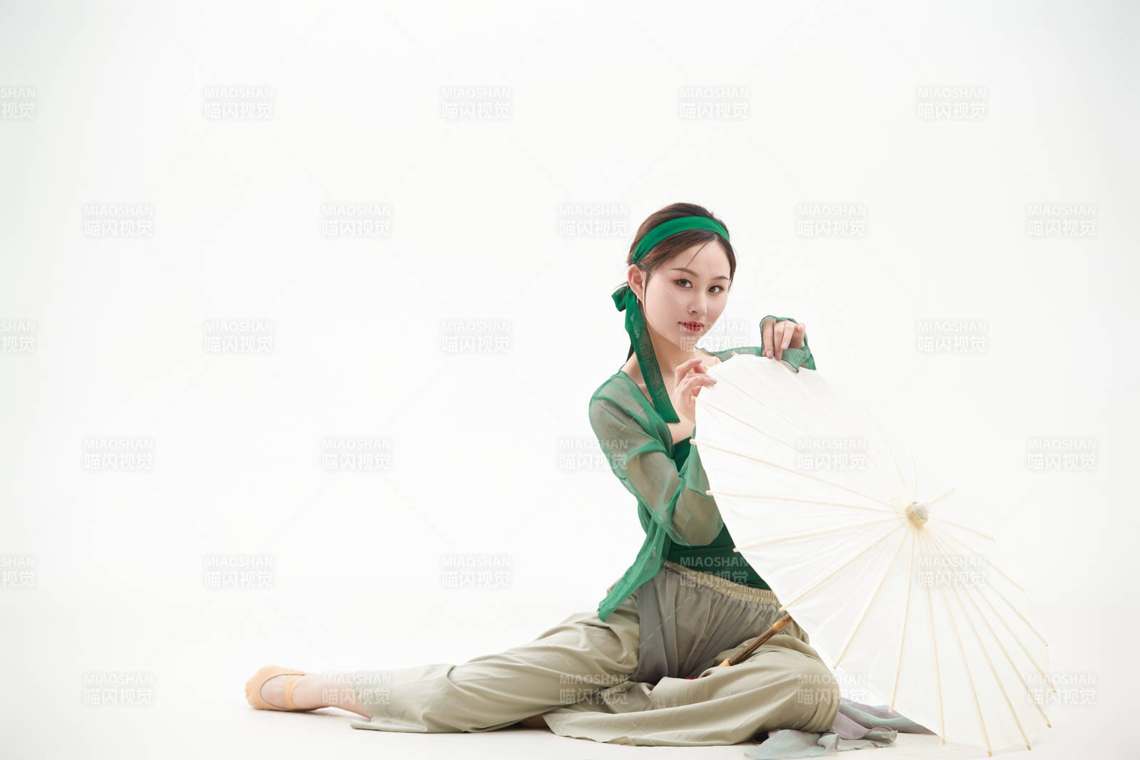 身穿青色古典舞蹈服裝手拿蒲扇跳舞的少女