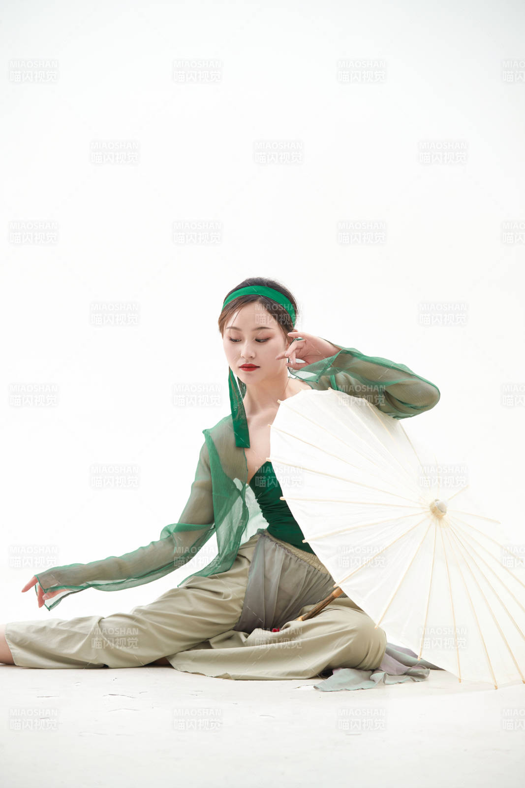 身穿青色古典舞蹈服裝手拿蒲扇跳舞的少女