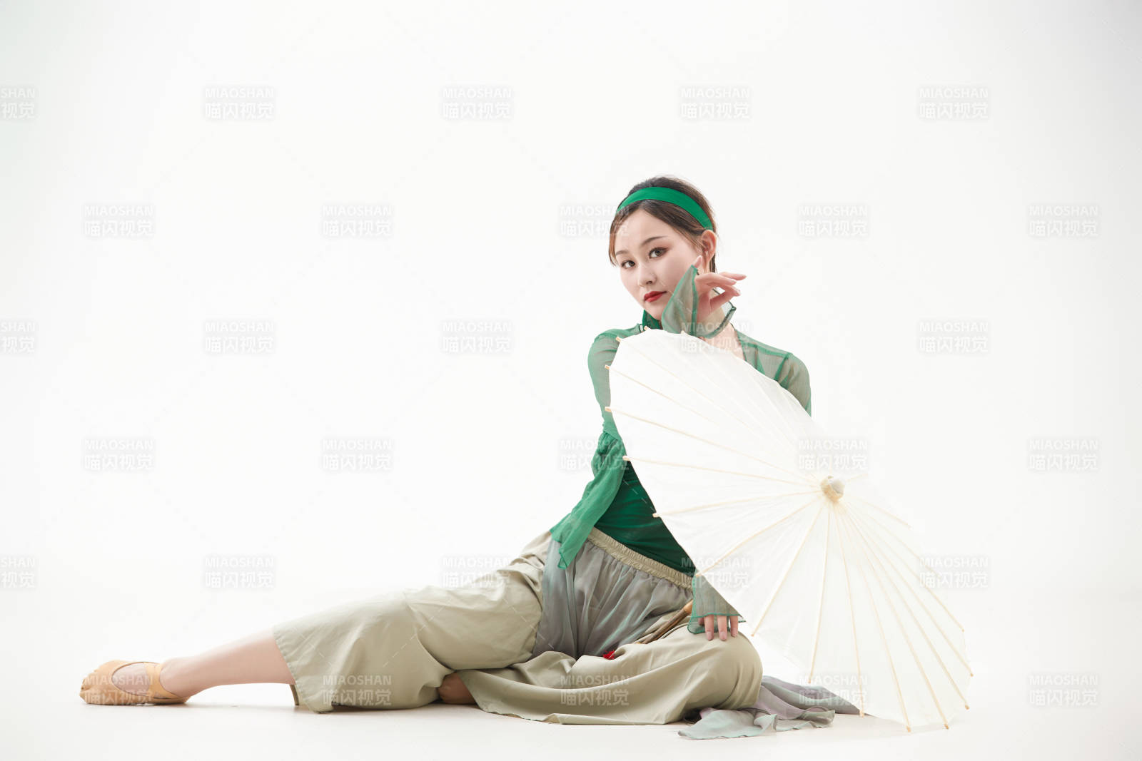 身穿青色古典舞蹈服裝手拿蒲扇跳舞的少女