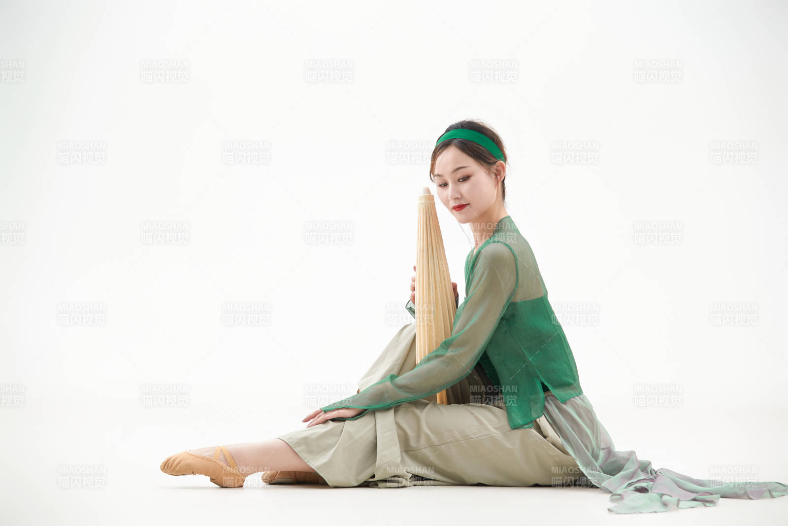 身穿青色古典舞蹈服裝手拿蒲扇跳舞的少女