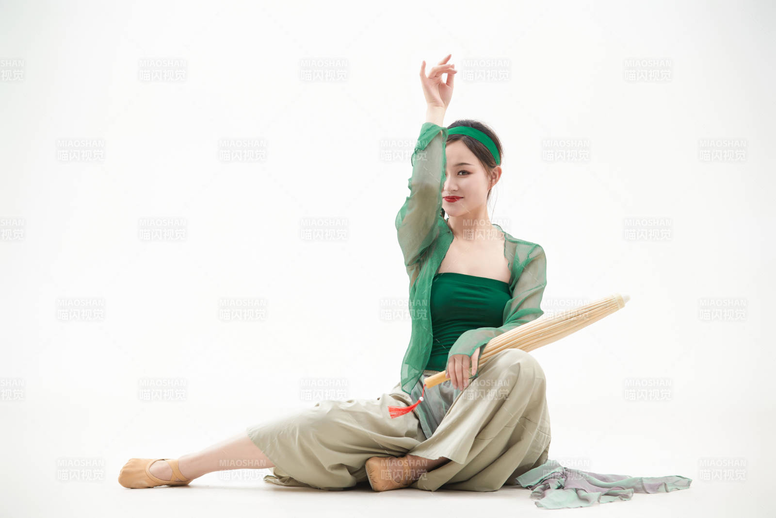 身穿青色古典舞蹈服裝手拿蒲扇跳舞的少女