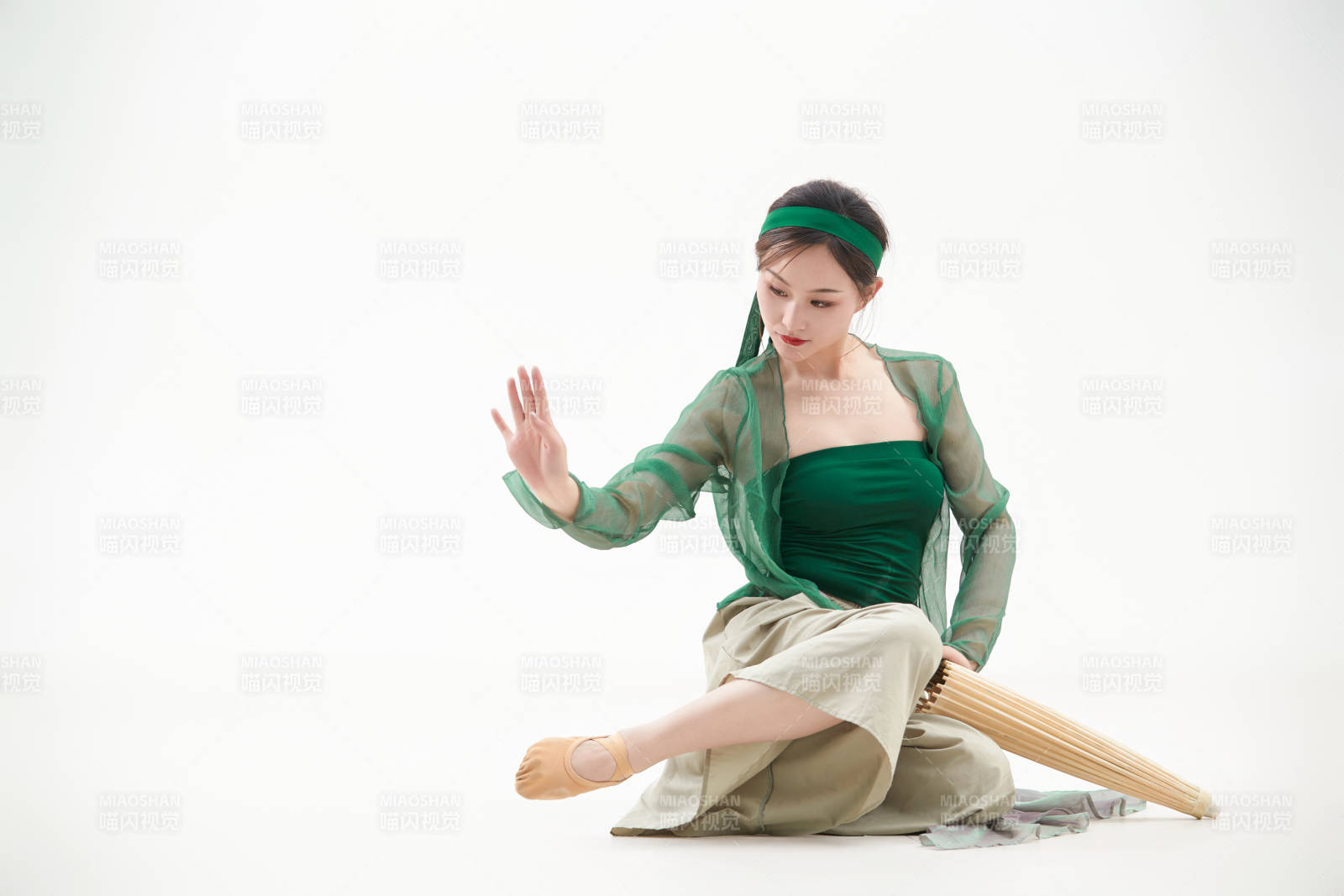 身穿青色古典舞蹈服裝手拿蒲扇跳舞的少女