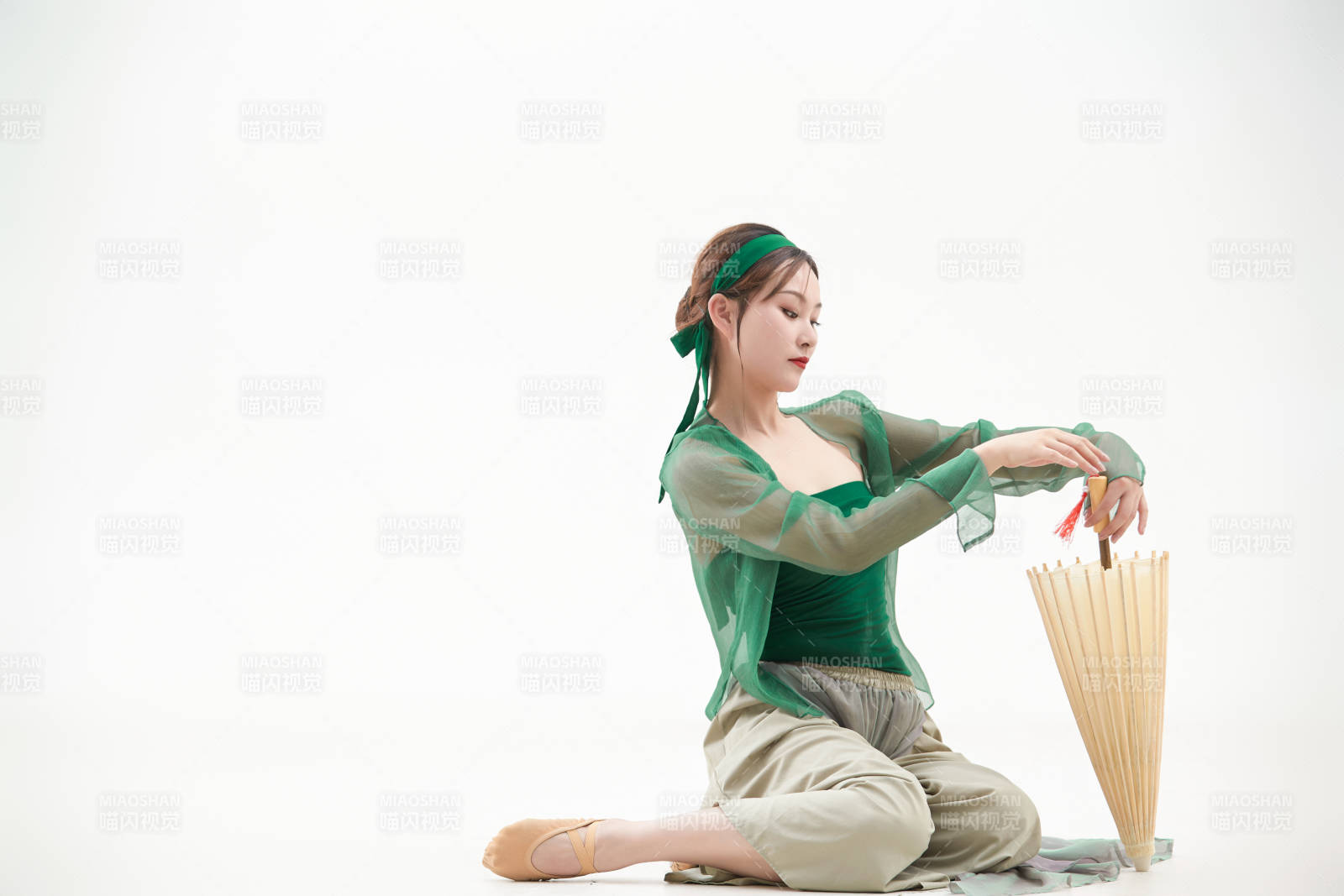 身穿青色古典舞蹈服裝手拿蒲扇跳舞的少女