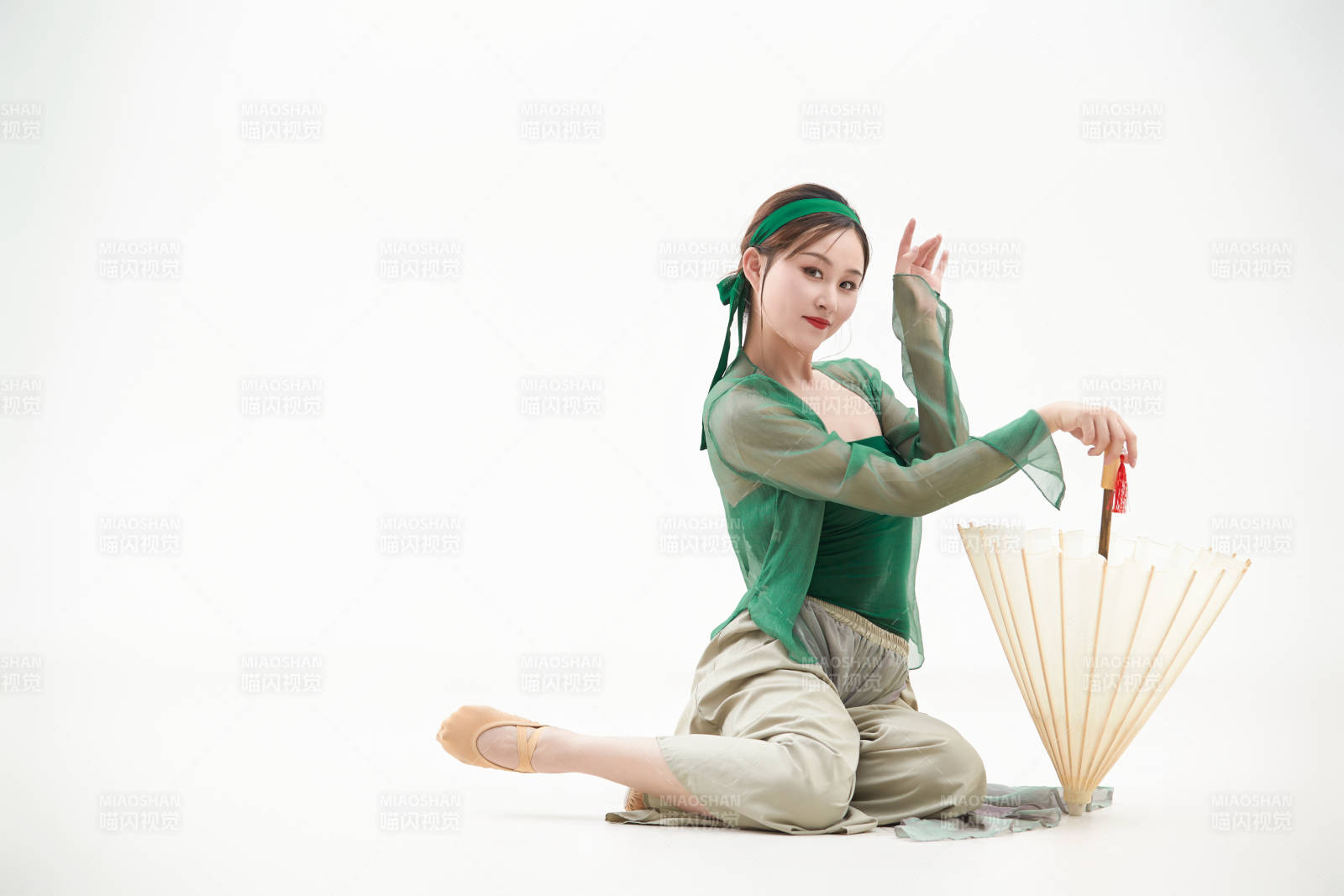 身穿青色古典舞蹈服裝手拿蒲扇跳舞的少女