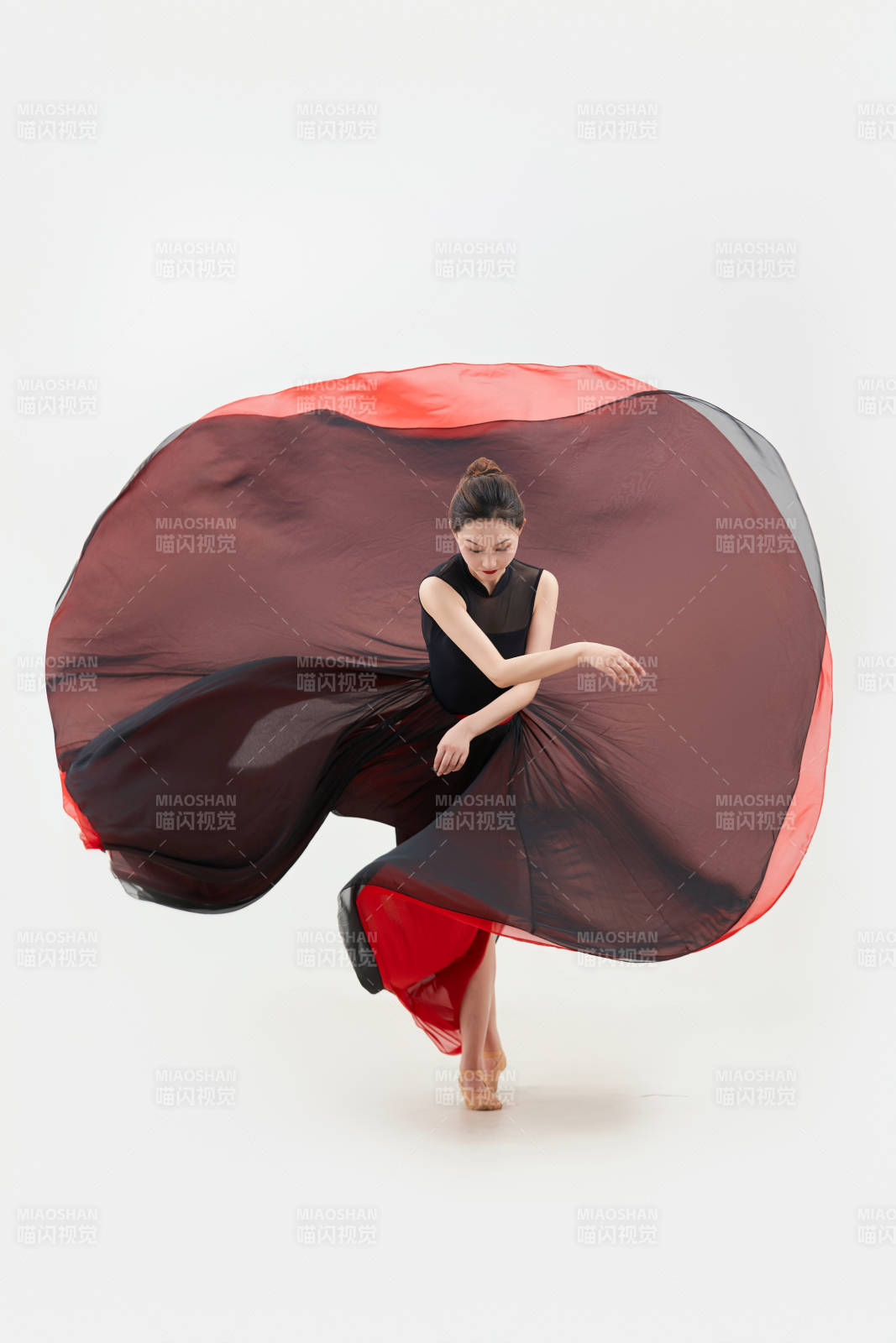 身穿紅黑相間的舞蹈長裙翩翩起舞的少女