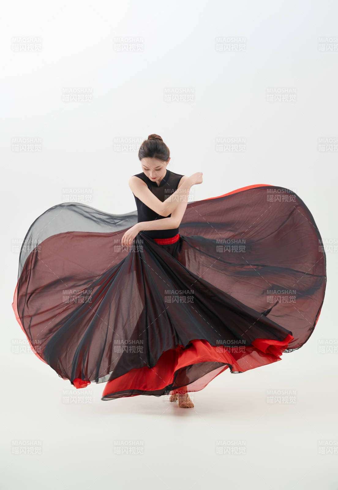 身穿紅黑相間的舞蹈長裙翩翩起舞的少女