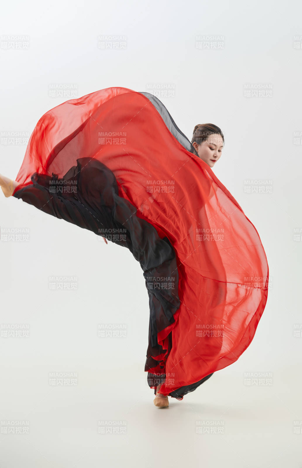 身穿紅黑相間的舞蹈長裙翩翩起舞的少女