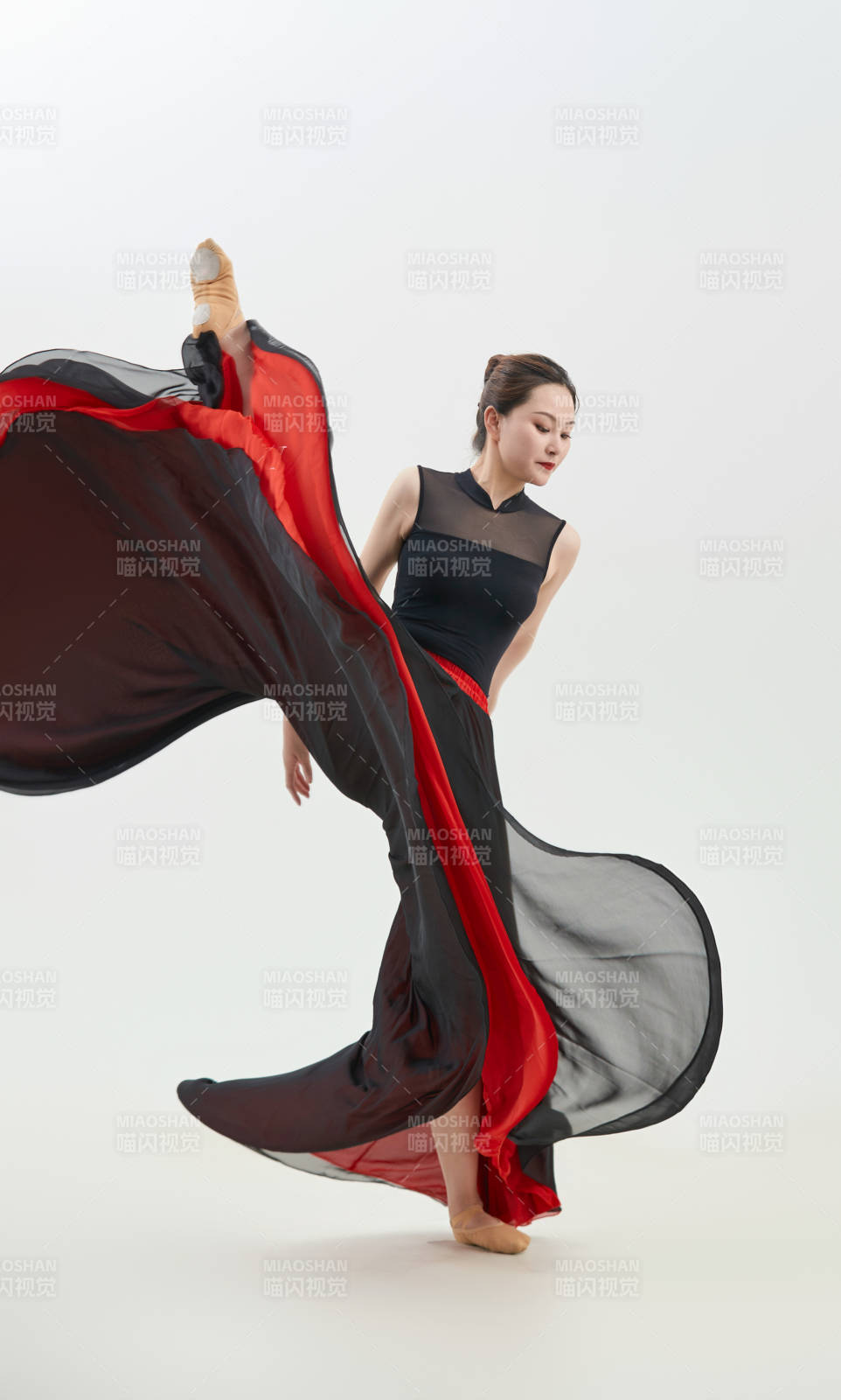 身穿紅黑相間的舞蹈長裙翩翩起舞的少女