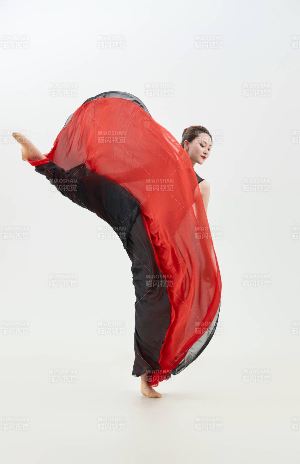 身穿紅黑相間的舞蹈長裙翩翩起舞的少女