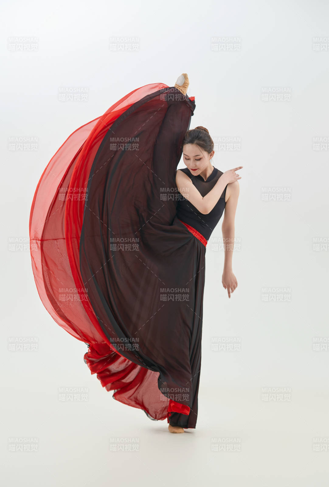 身穿紅黑相間的舞蹈長裙翩翩起舞的少女