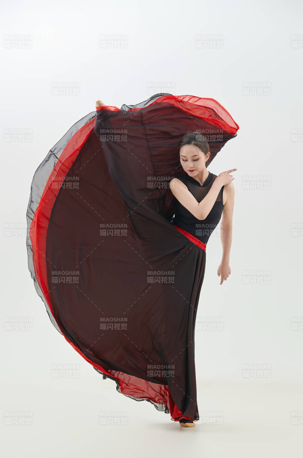 身穿紅黑相間的舞蹈長裙翩翩起舞的少女