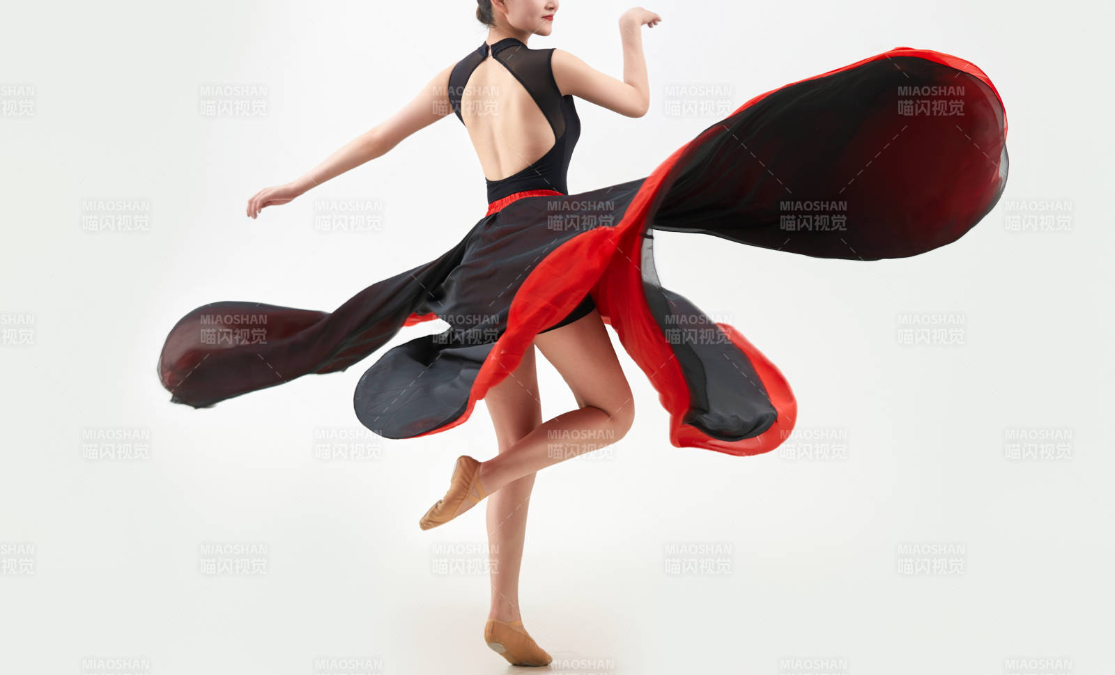 身穿紅黑相間的舞蹈長裙翩翩起舞的少女