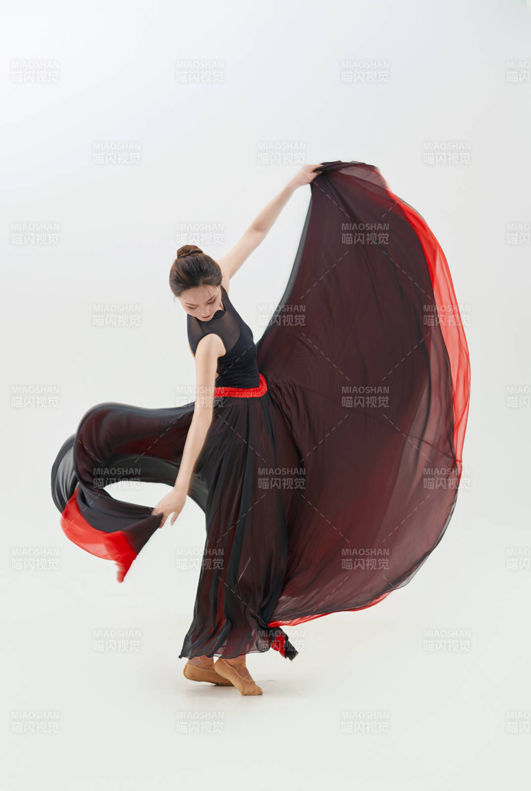 身穿紅黑相間的舞蹈長裙翩翩起舞的少女