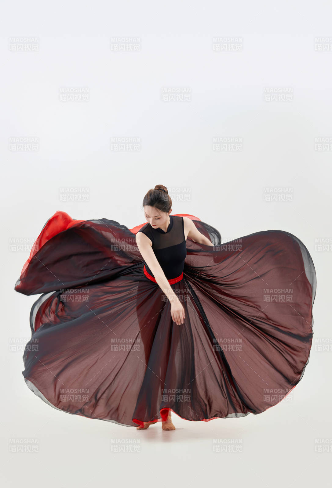 身穿紅黑相間的舞蹈長裙翩翩起舞的少女