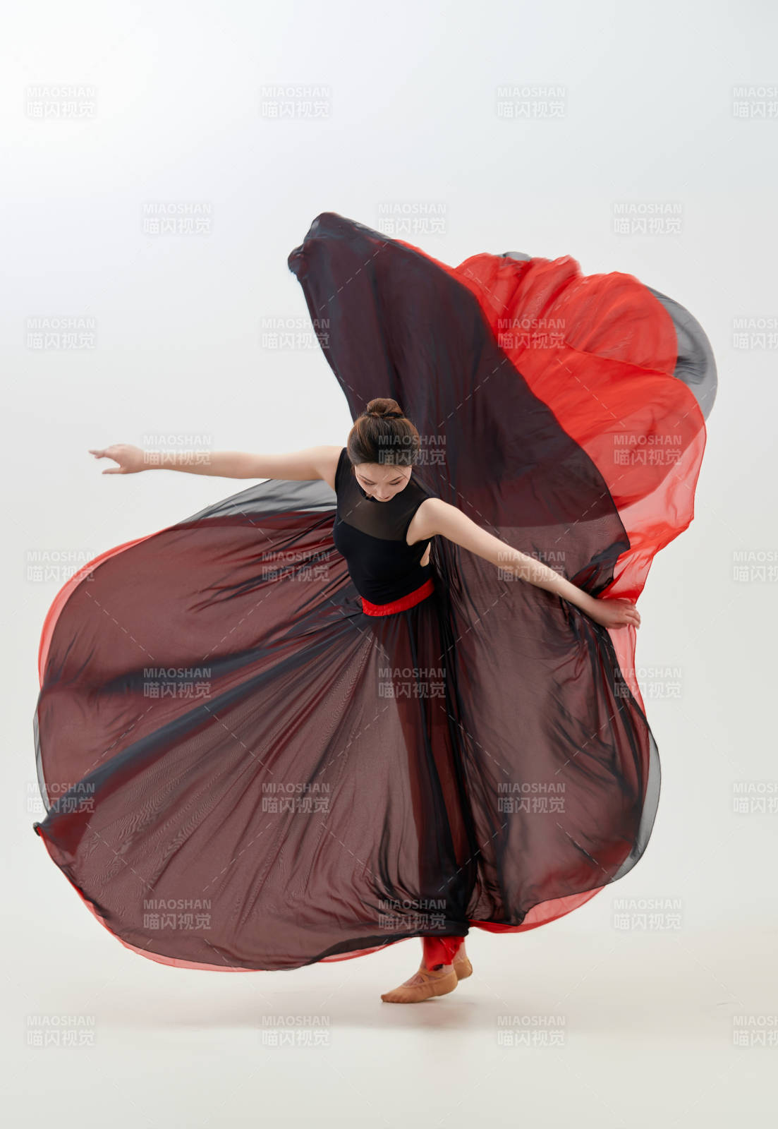 身穿紅黑相間的舞蹈長裙翩翩起舞的少女