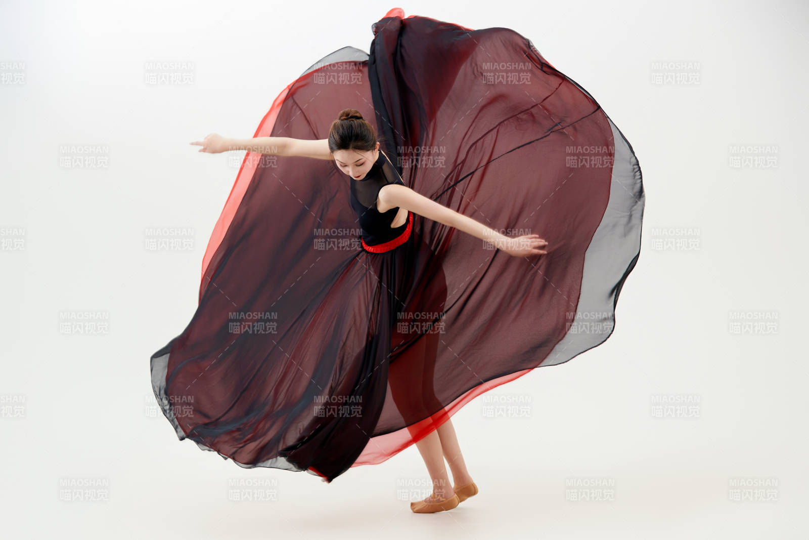 身穿紅黑相間的舞蹈長裙翩翩起舞的少女