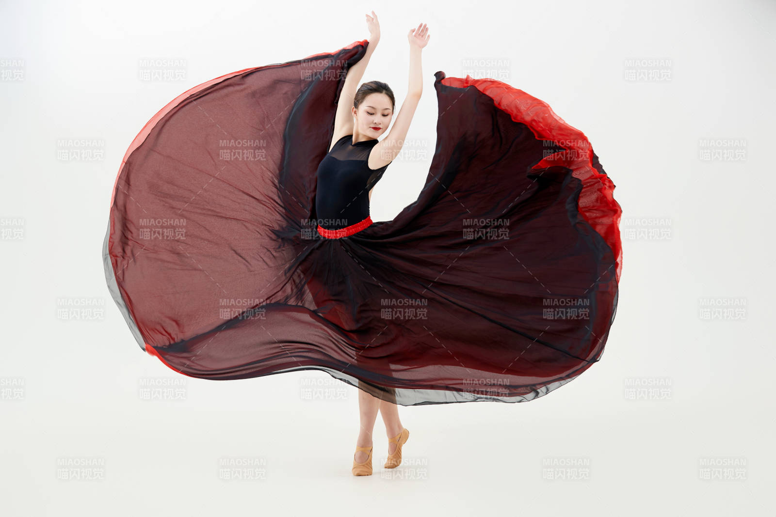 身穿紅黑相間的舞蹈長裙翩翩起舞的少女