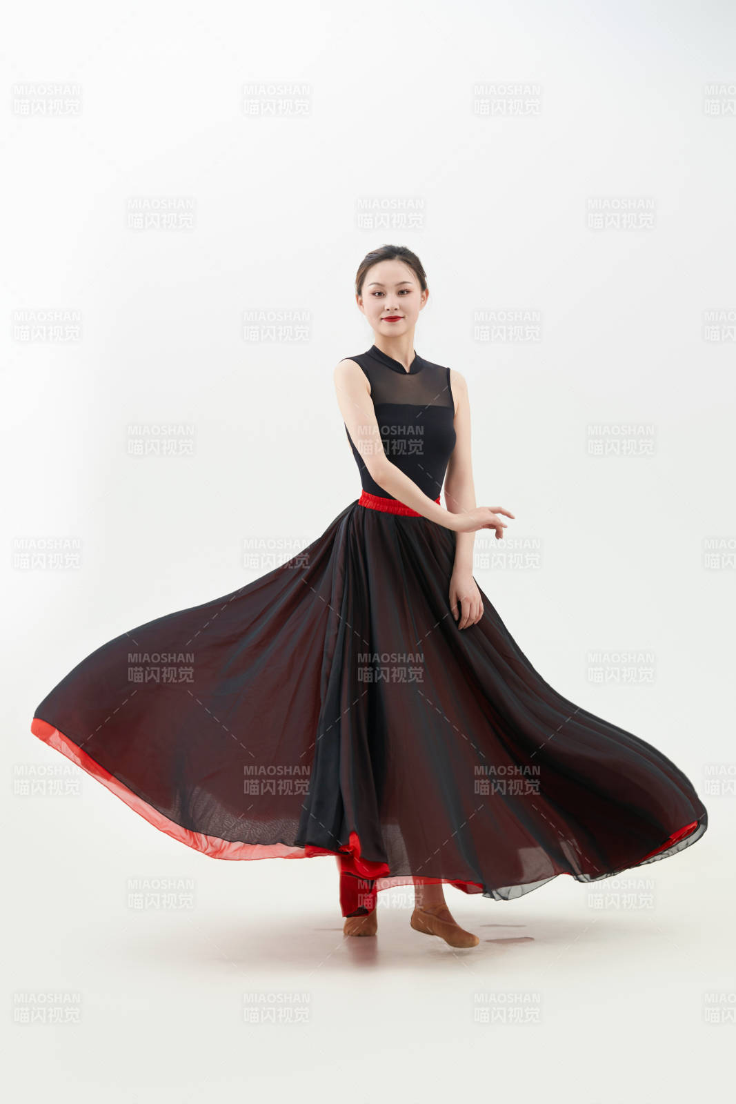 身穿紅黑相間的舞蹈長(zhǎng)裙翩翩起舞的少女