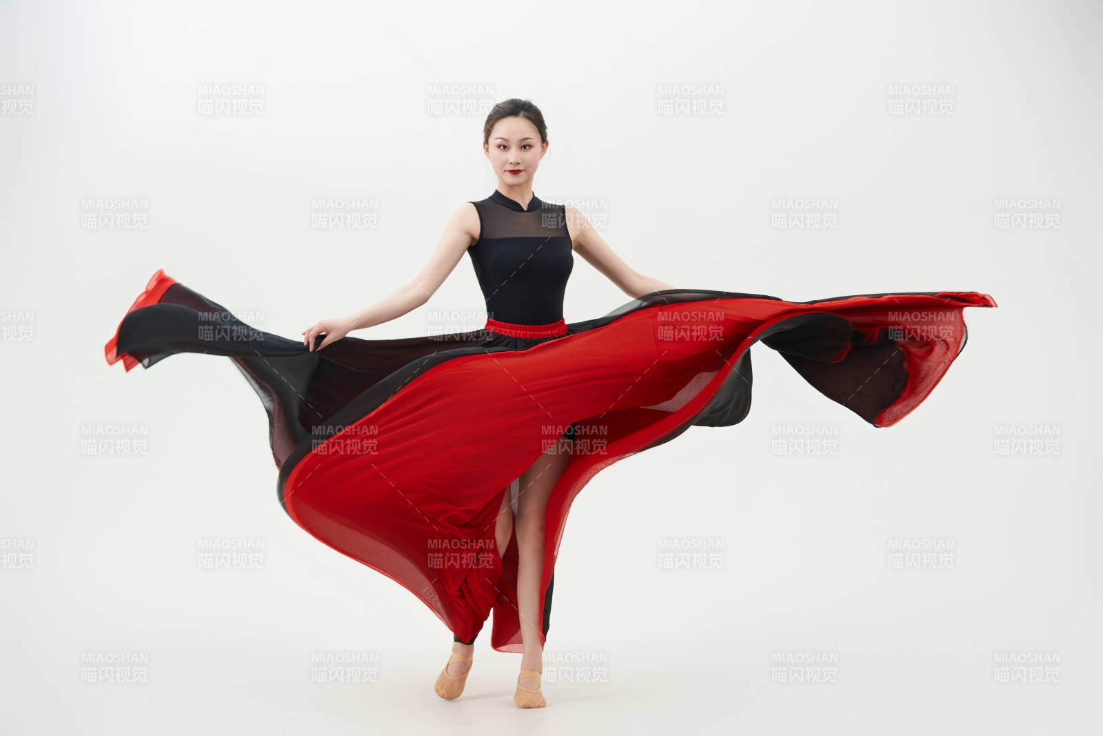 身穿紅黑相間的舞蹈長裙翩翩起舞的少女