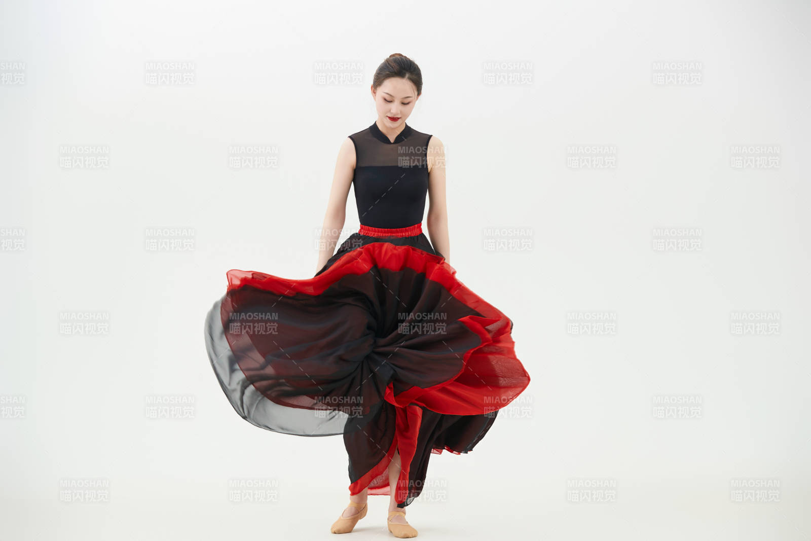 身穿紅黑相間的舞蹈長裙翩翩起舞的少女
