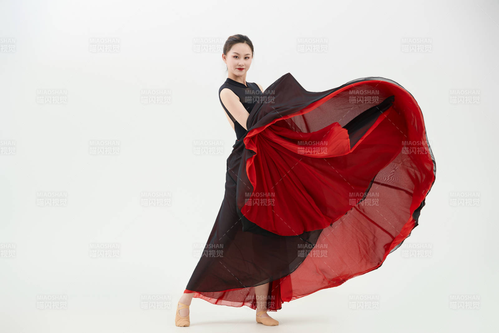 身穿紅黑相間的舞蹈長裙翩翩起舞的少女