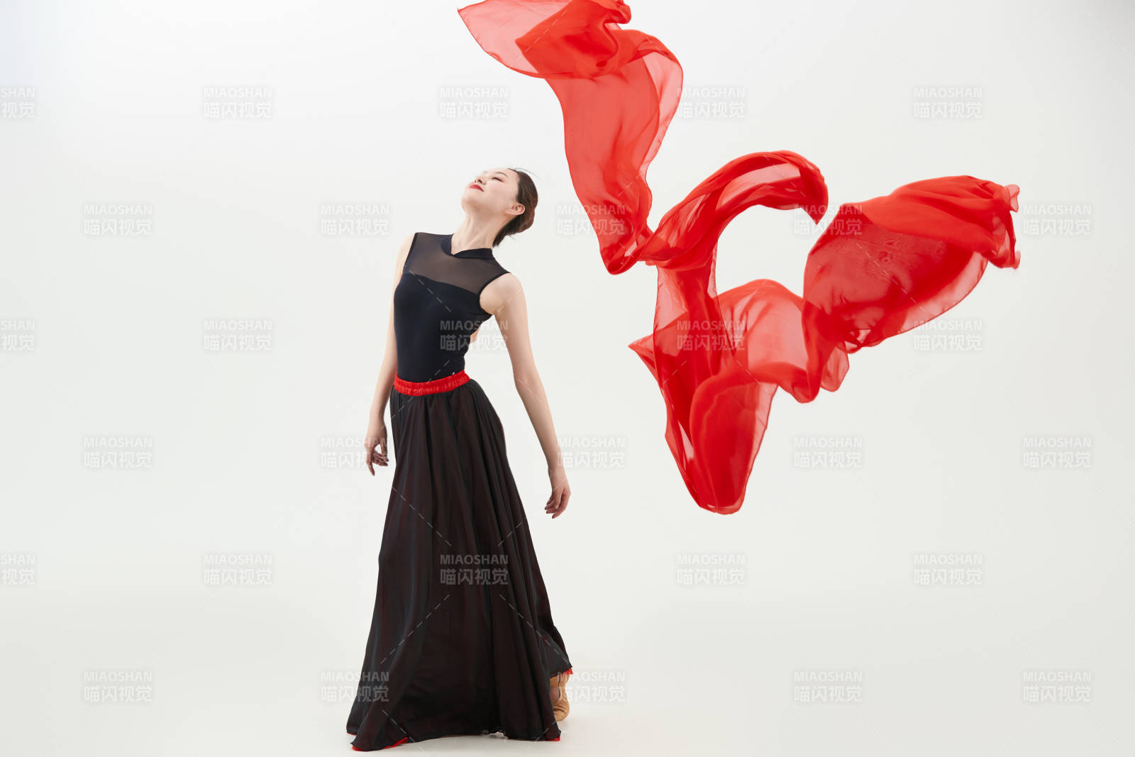 身穿紅黑相間的舞蹈長裙翩翩起舞的少女