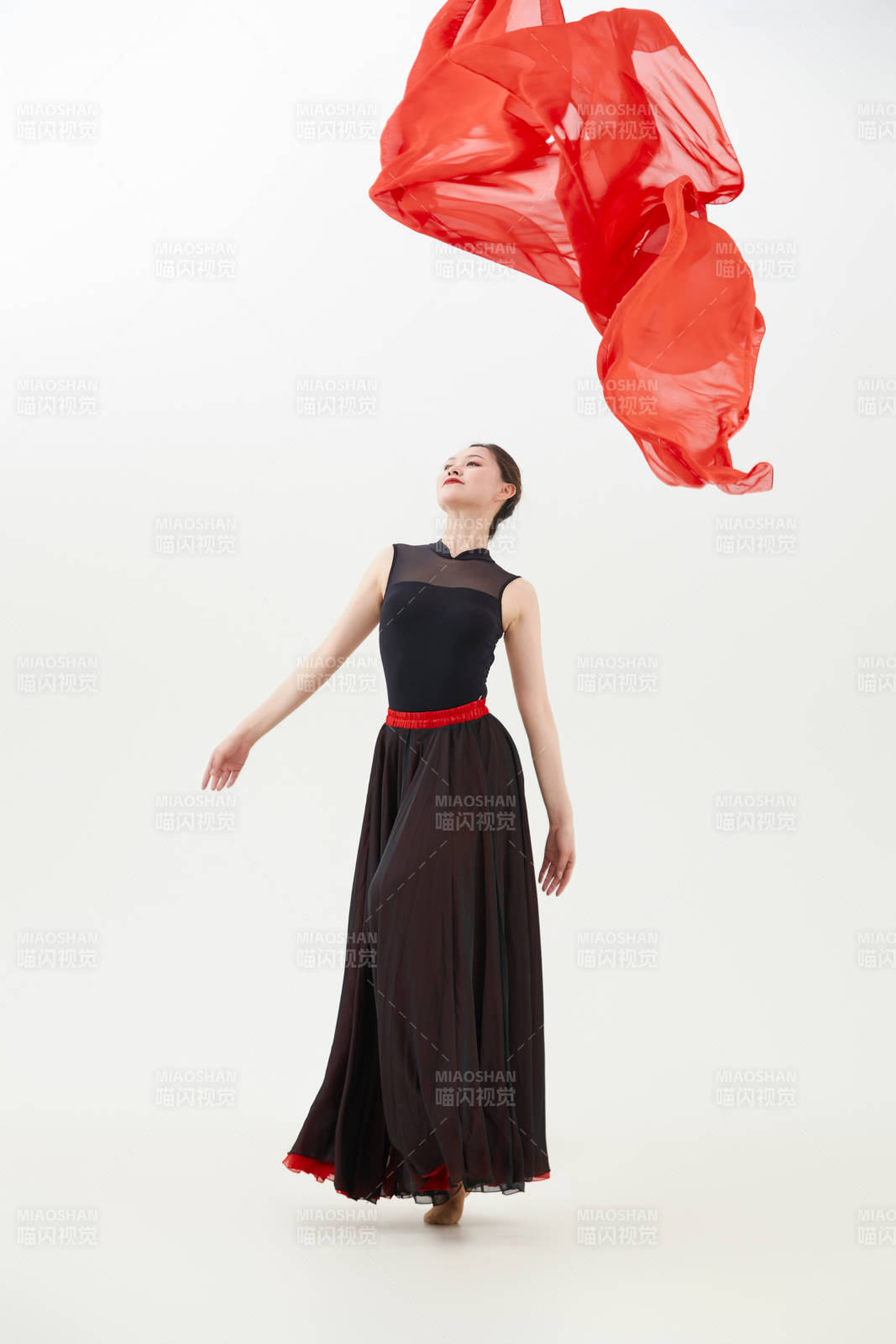 身穿紅黑相間的舞蹈長裙翩翩起舞的少女
