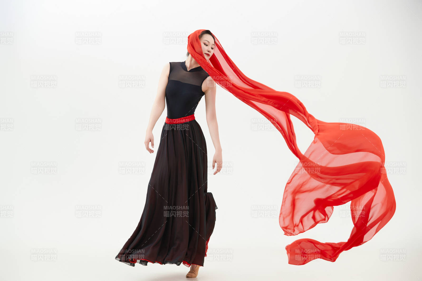 身穿紅黑相間的舞蹈長裙翩翩起舞的少女