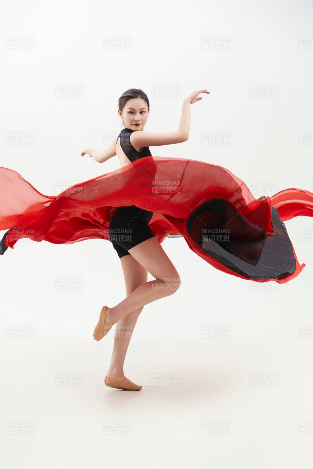 身穿紅黑相間的舞蹈長裙翩翩起舞的少女