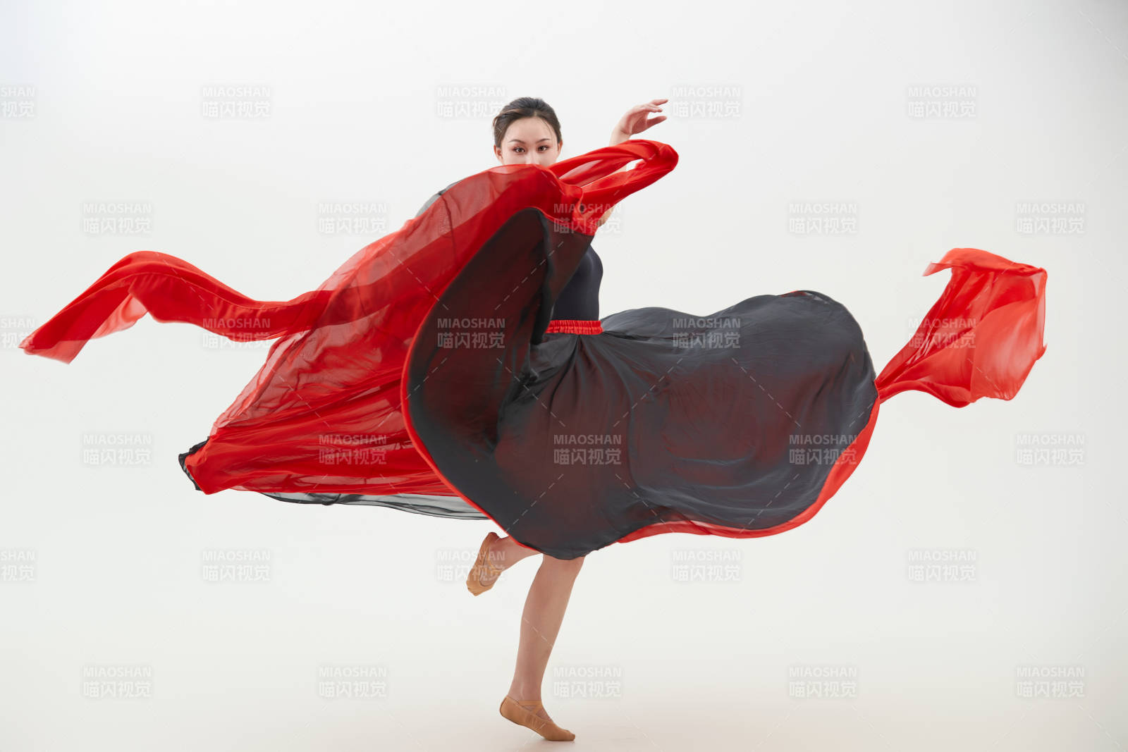 身穿紅黑相間的舞蹈長裙翩翩起舞的少女