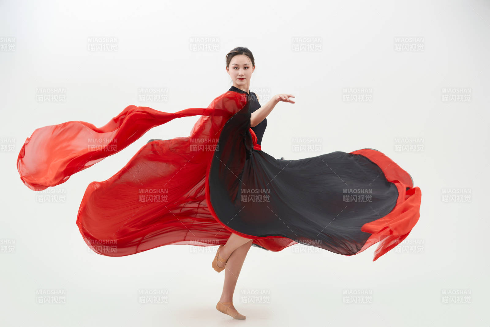 身穿紅黑相間的舞蹈長裙翩翩起舞的少女