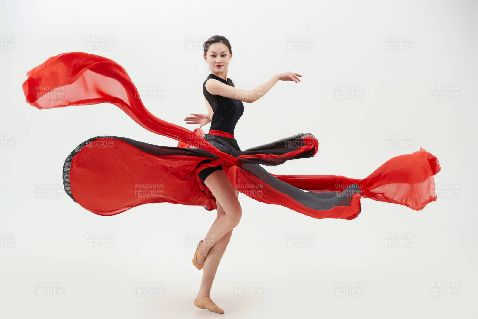 身穿紅黑相間的舞蹈長裙翩翩起舞的少女