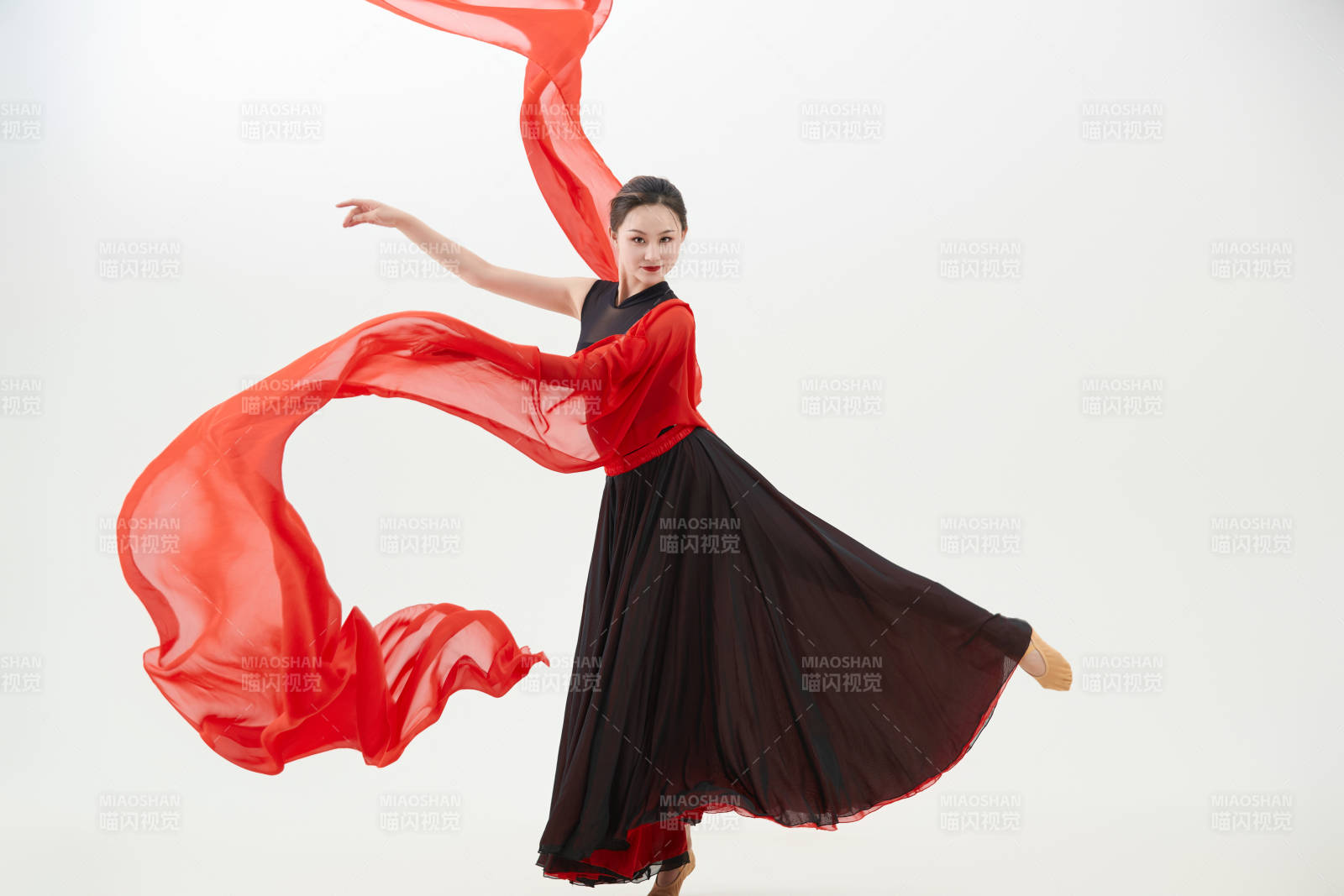 身穿紅黑相間的舞蹈長(zhǎng)裙翩翩起舞的少女