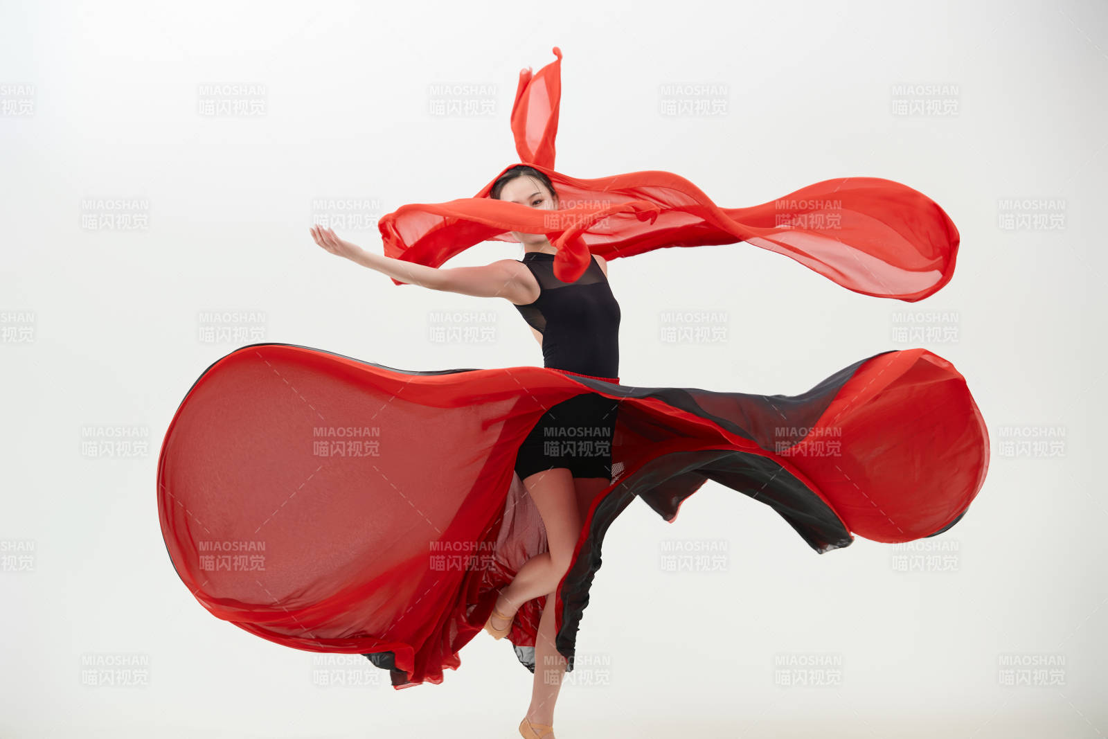 身穿紅黑相間的舞蹈長裙翩翩起舞的少女