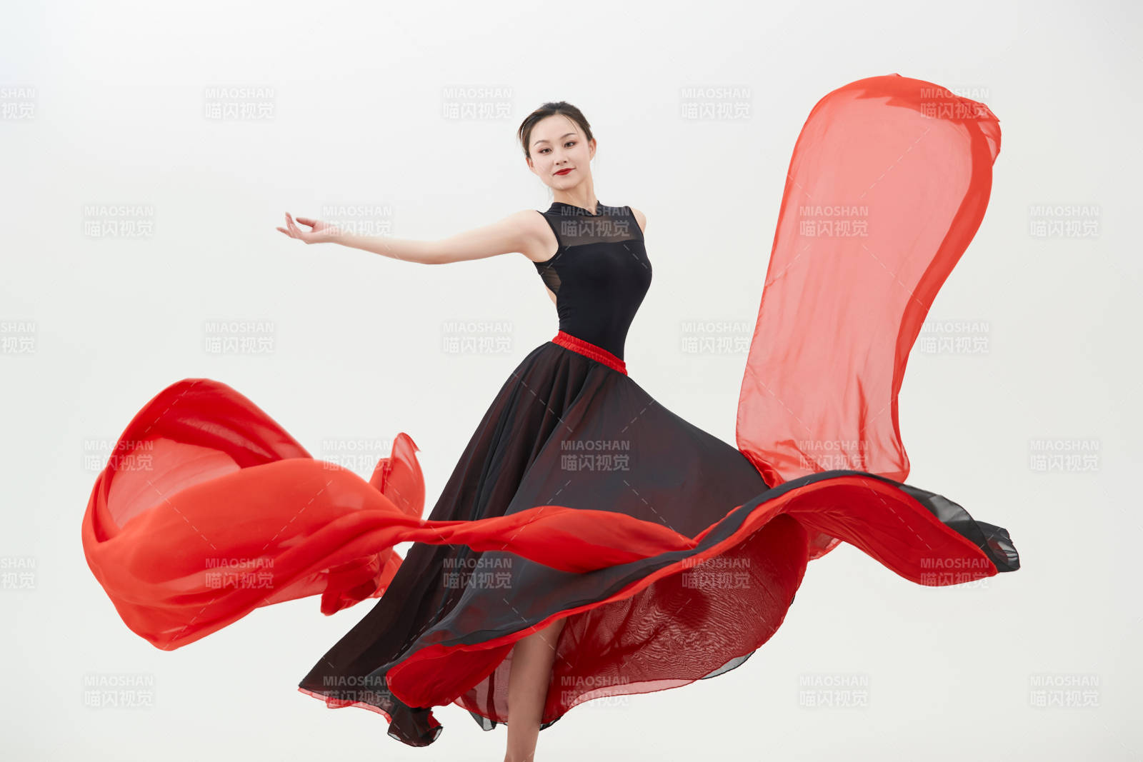 身穿紅黑相間的舞蹈長裙翩翩起舞的少女
